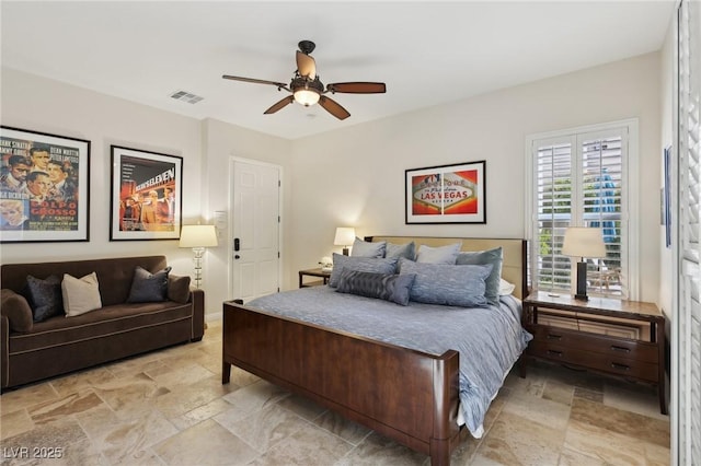 bedroom featuring a ceiling fan, visible vents, and stone tile flooring