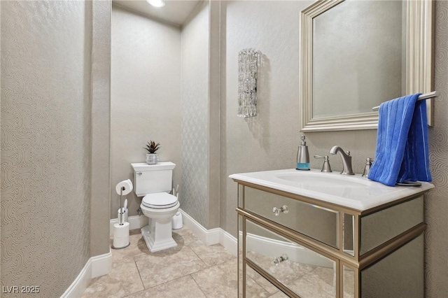 bathroom with tile patterned flooring, baseboards, vanity, and toilet