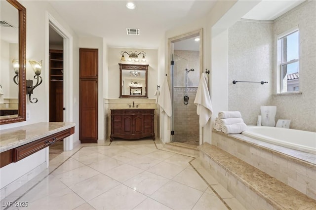 bathroom featuring a stall shower, visible vents, a garden tub, and vanity