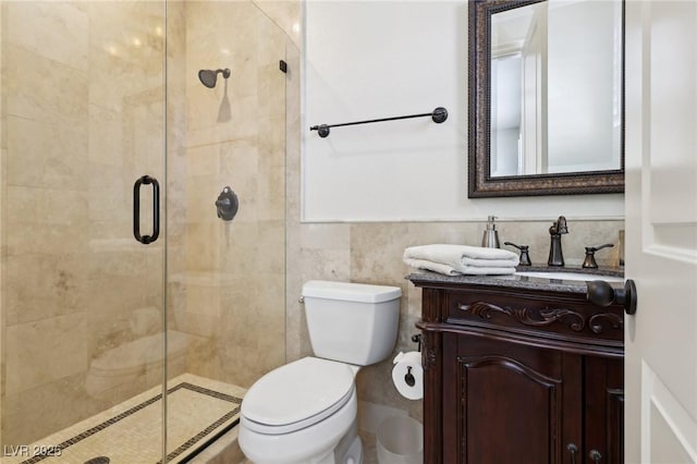 full bathroom featuring tile walls, toilet, a shower stall, and vanity