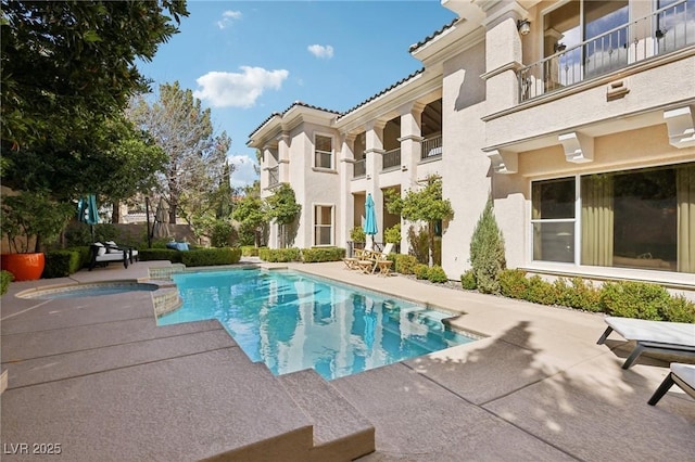 view of pool featuring a patio and a pool with connected hot tub