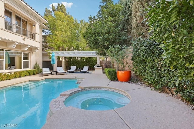 view of swimming pool featuring a patio area, a pool with connected hot tub, and a pergola