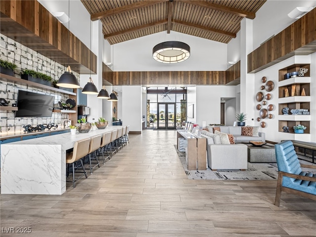 living room with light wood-style floors, wooden ceiling, high vaulted ceiling, and beam ceiling