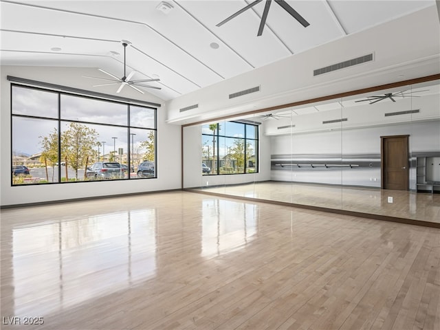 exercise room featuring vaulted ceiling, visible vents, ceiling fan, and wood finished floors