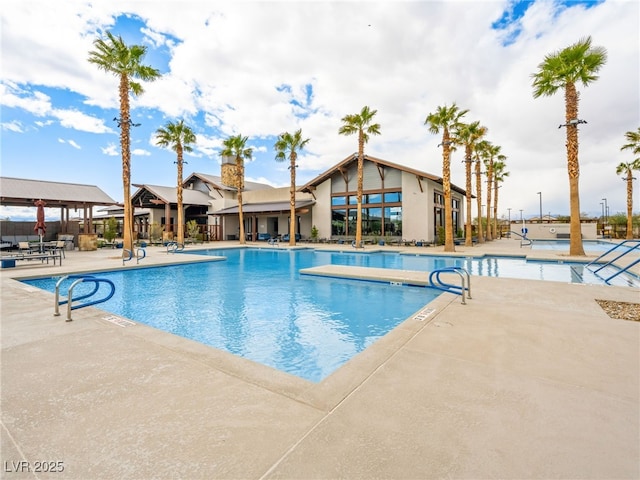 pool with a patio area and fence