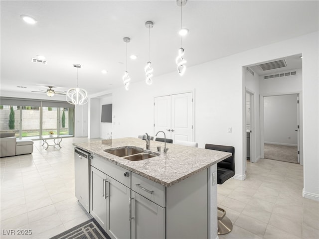 kitchen with visible vents, gray cabinetry, open floor plan, a sink, and dishwasher