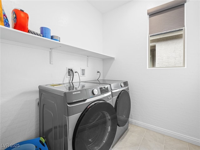 washroom with laundry area, light tile patterned floors, baseboards, and separate washer and dryer