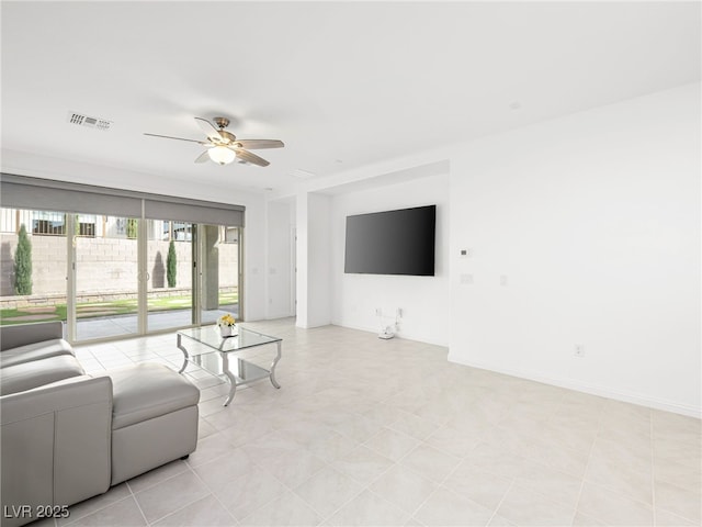 living area featuring baseboards, visible vents, and a ceiling fan