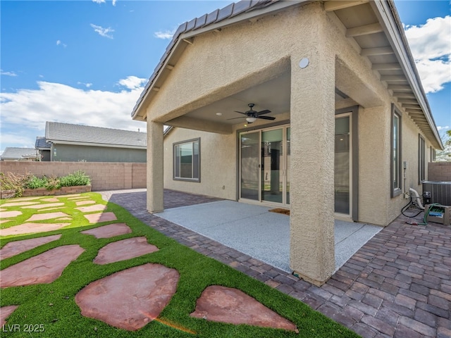 back of property with ceiling fan, fence, a patio, and stucco siding