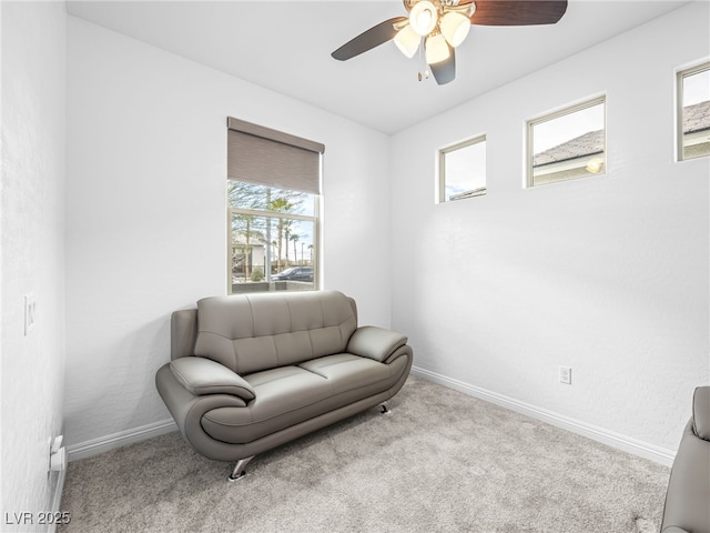 sitting room with carpet floors, a ceiling fan, and baseboards