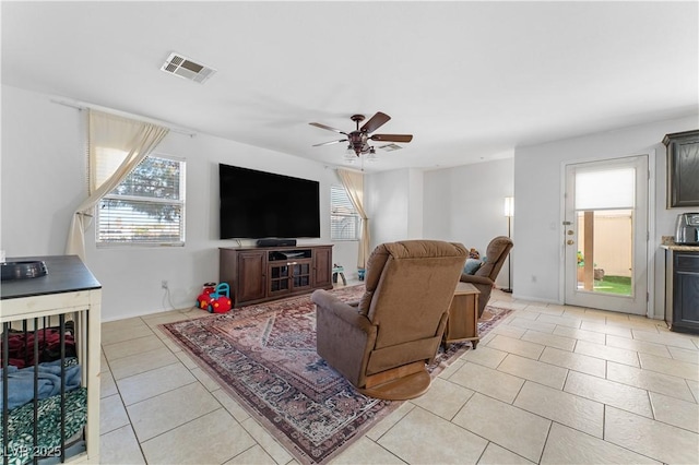 living room with light tile patterned flooring, a ceiling fan, and visible vents