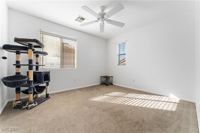 interior space with visible vents, carpet floors, baseboards, and a ceiling fan