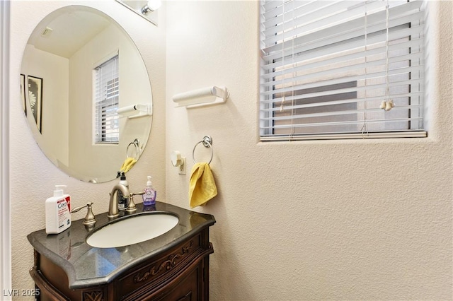 bathroom with vanity and a textured wall