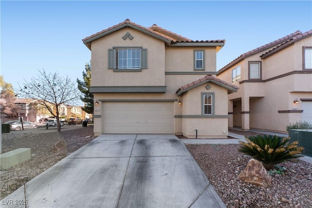 view of front of property featuring driveway, a tiled roof, a garage, and stucco siding