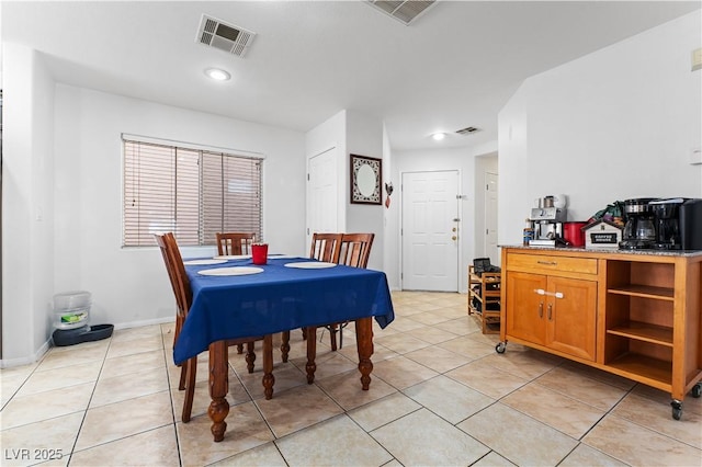 dining space with light tile patterned floors, visible vents, and baseboards