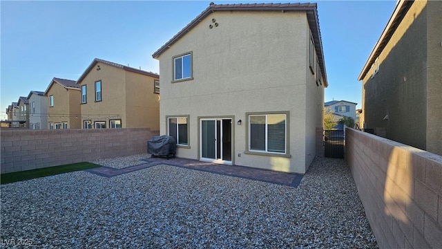 rear view of property featuring a patio area, a fenced backyard, and stucco siding