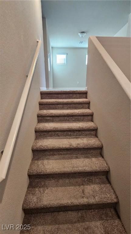 staircase featuring a textured wall