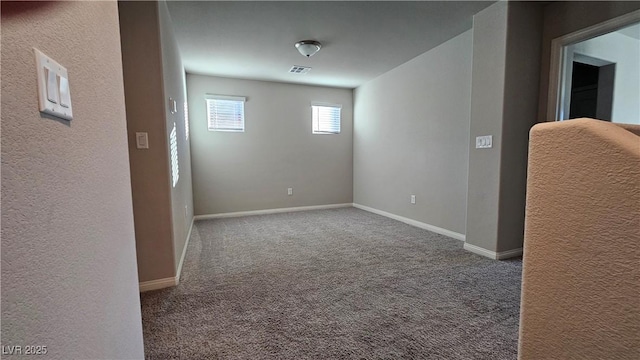 carpeted spare room featuring baseboards and visible vents