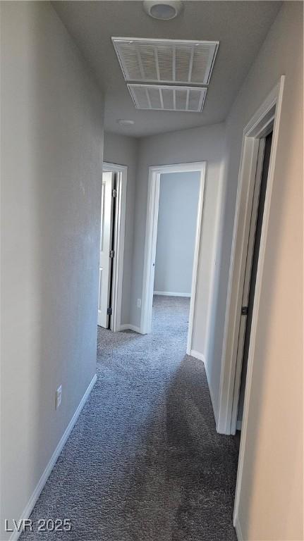 hall with carpet, visible vents, and baseboards