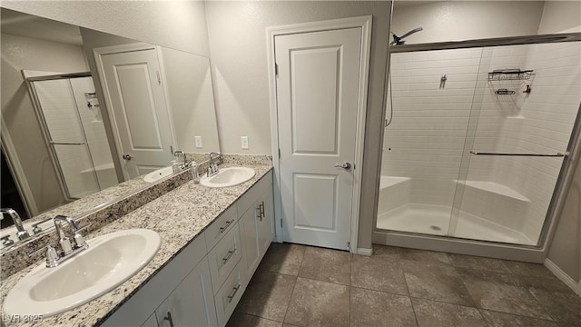 bathroom with double vanity, a stall shower, and a sink