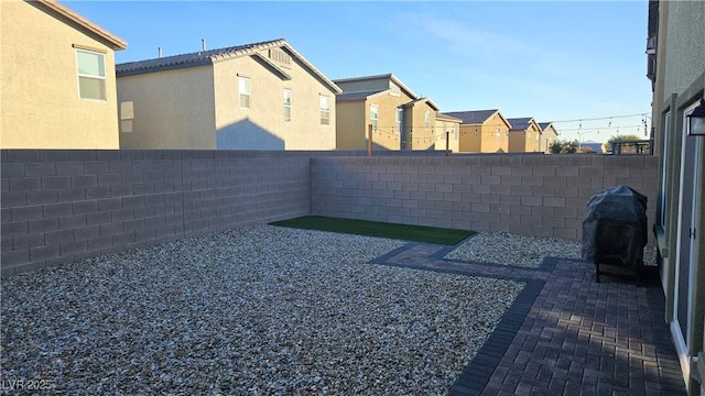 view of yard with a residential view, a patio area, and a fenced backyard