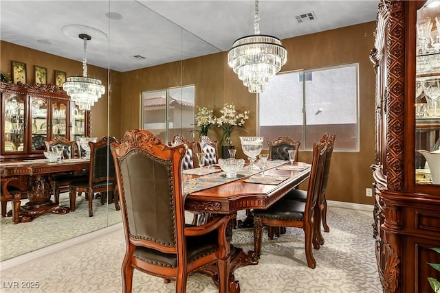 dining area with baseboards, visible vents, and a notable chandelier