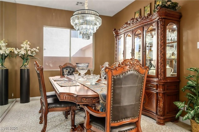 dining area featuring visible vents, a notable chandelier, and baseboards