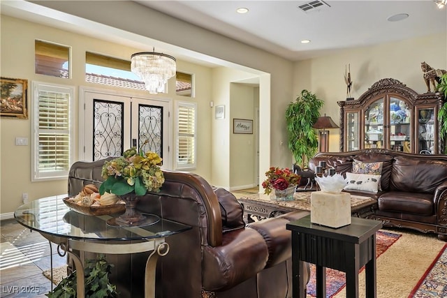 living area featuring baseboards, visible vents, a notable chandelier, and recessed lighting