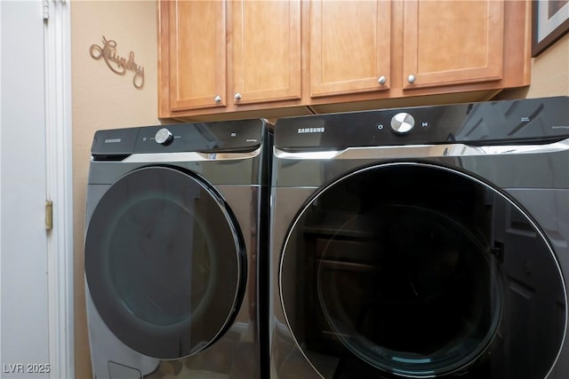 laundry area with separate washer and dryer and cabinet space