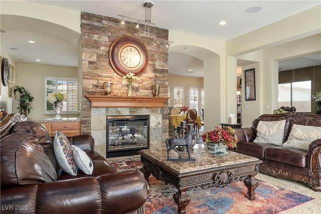 living room with a large fireplace, plenty of natural light, and recessed lighting