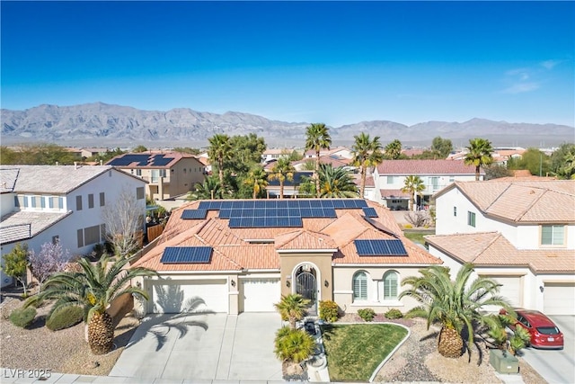 view of front of home featuring a mountain view, driveway, a tiled roof, and a residential view