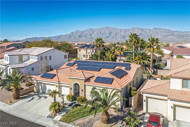 view of front of home with a garage, a residential view, a mountain view, and a tiled roof