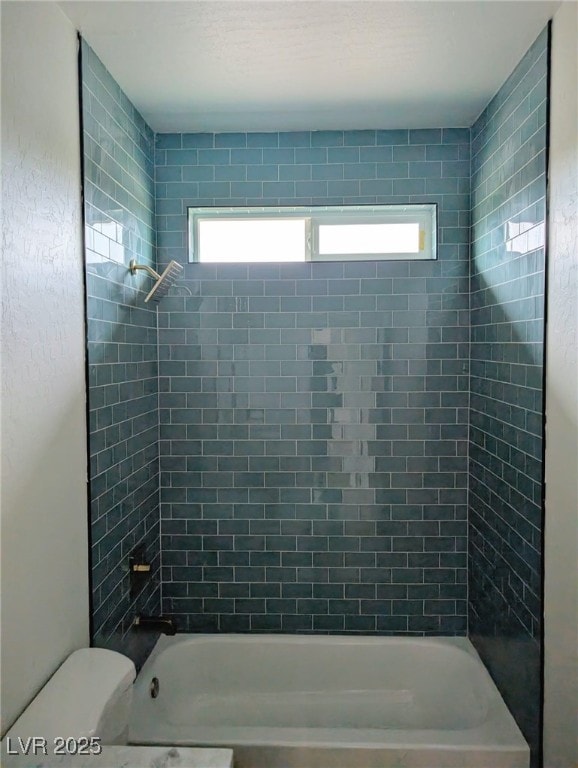 bathroom with tub / shower combination and toilet