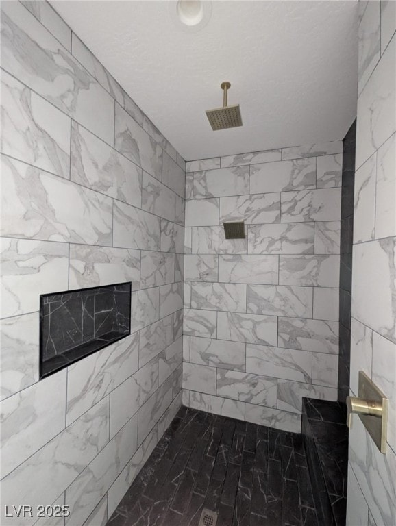 full bathroom featuring tiled shower and a fireplace