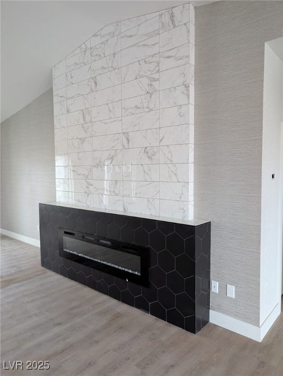 details with baseboards, wood finished floors, and a glass covered fireplace