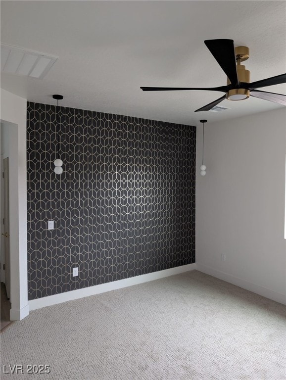 carpeted spare room with ceiling fan and baseboards