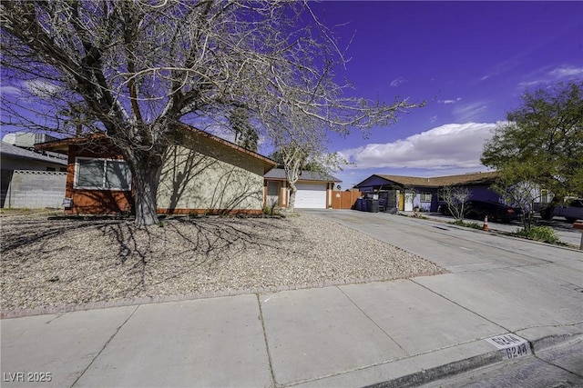 single story home with an attached garage, fence, and concrete driveway