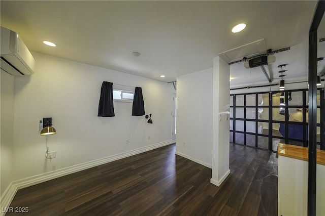 basement with recessed lighting, a wall unit AC, wood finished floors, and baseboards