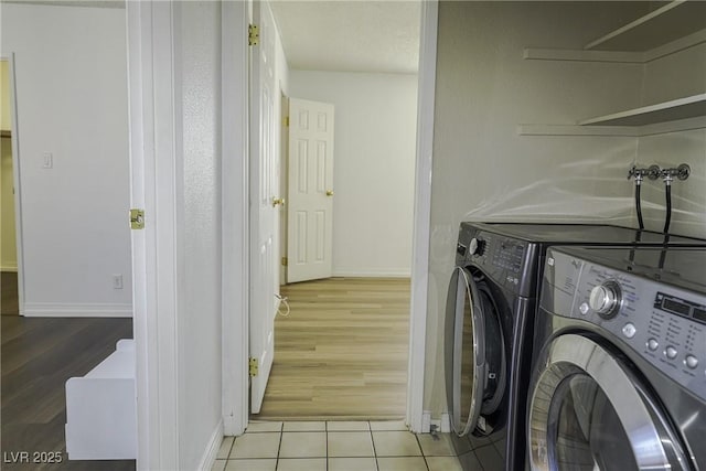 laundry room featuring laundry area, tile patterned flooring, baseboards, and independent washer and dryer