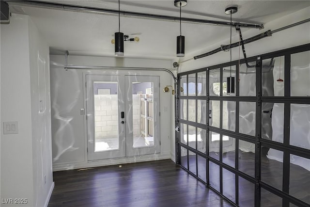 doorway featuring dark wood-style floors, baseboards, and a wealth of natural light