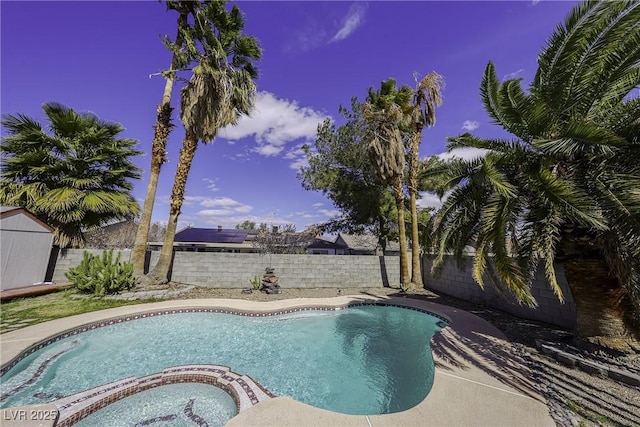 view of swimming pool with a pool with connected hot tub and a fenced backyard