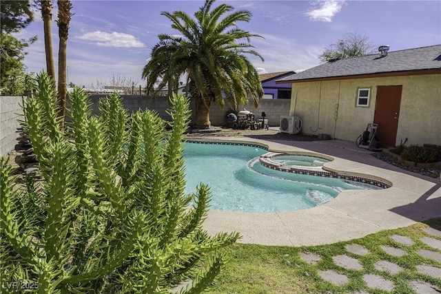 view of swimming pool featuring a pool with connected hot tub, a fenced backyard, and a patio