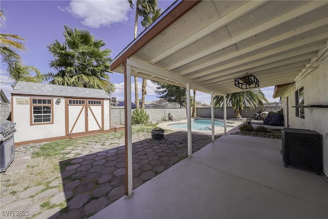 view of patio / terrace with an outbuilding, a fenced backyard, and a shed