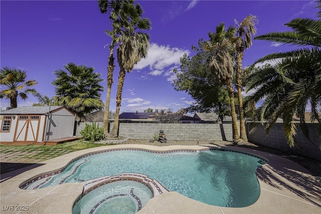 view of swimming pool featuring a pool with connected hot tub, a fenced backyard, an outdoor structure, and a shed