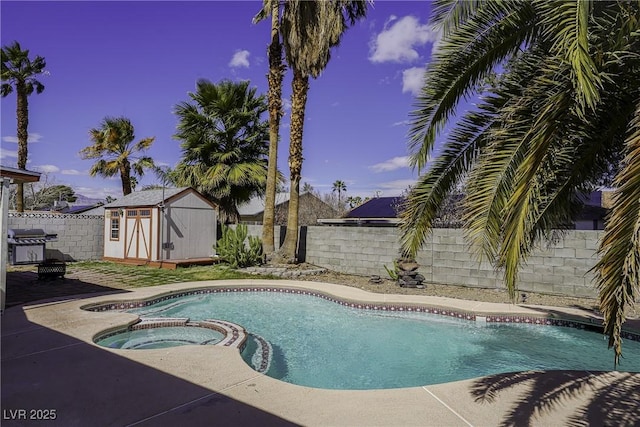 view of swimming pool with a storage shed, a fenced backyard, a pool with connected hot tub, and an outbuilding