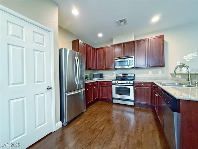 kitchen with dark wood-style flooring, stainless steel appliances, recessed lighting, visible vents, and a sink