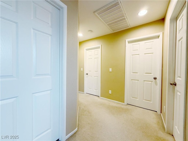 hall featuring light carpet, baseboards, visible vents, and recessed lighting