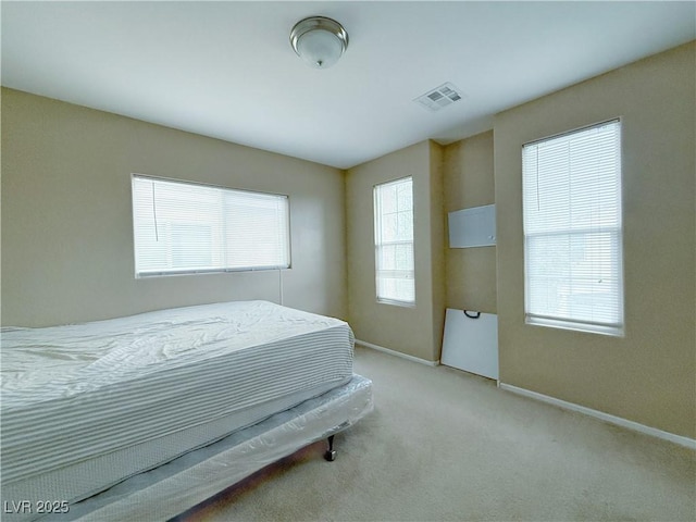 carpeted bedroom featuring visible vents and baseboards