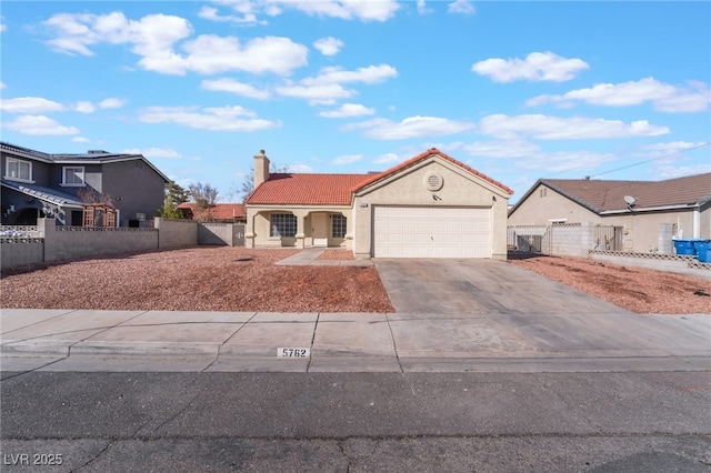 view of front facade featuring concrete driveway, fence, a tiled roof, and stucco siding