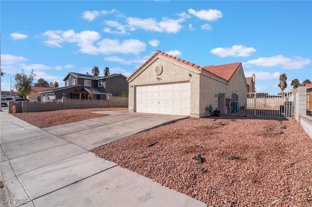 view of front of house featuring stucco siding, an attached garage, fence, driveway, and a tiled roof